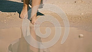 Young woman cautiously enters the lake water. body part,