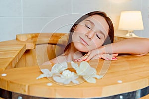 Young woman in cedar barrel. Spa ,medical procedures, skin care and treatment. Sauna and Hammam