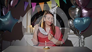 Young woman celebrating her birthday alone. Girl in protective medical mask