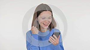 Young Woman Celebrating Success on Smartphone on White Background