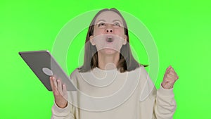 Young Woman Celebrating Success on Tablet on Green Background