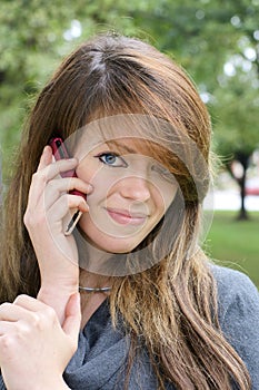 Young woman with cell phone looking at camera