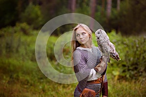 Young woman in chain mail with owl looking away