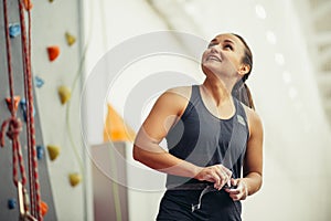 Young woman with chalked hands posing at indoor climbing gym wall