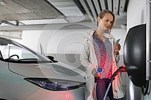 Young woman charging an electric vehicle