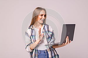 Young woman chatting on conference video call looking at laptop on white background