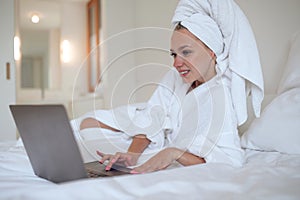 Young woman chatting online and looking contented