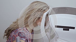 Young woman check her eyesight with modern equipment