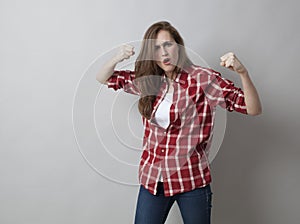 Young woman with checked shirt expressing aggresion