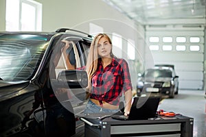 Young woman in checked shirt in a garage.