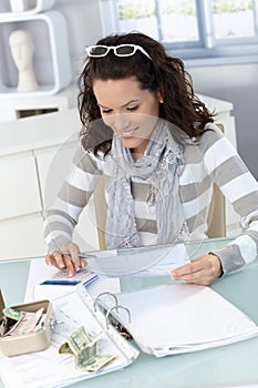 Young woman checking bills