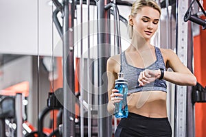 young woman checking fitness tracker after workout