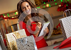 Young woman checking list of christmas presents