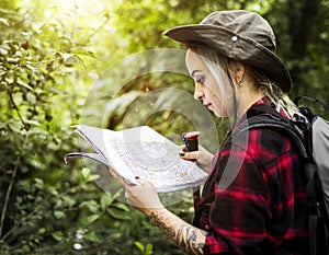 A young woman checking route map in the forest