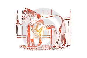 Young woman checking stallion horseshoe, equine care, female farmer in apron, purebred mare in stable