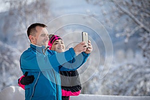 Young woman and cheerful man ejoying snowy winter weather