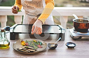 Young woman chef cooking outdoor while streaming online for webinar masterclass lesson at home during isolation quarantine - Food photo