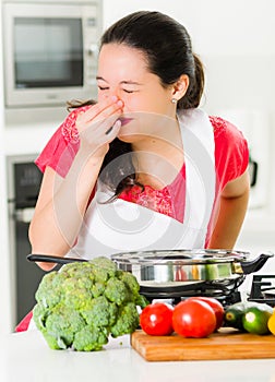 Young woman chef cooking with skeptical facial expressions, interacting frustrated body language