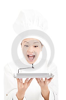 Young woman chef looking tray with amazing expression