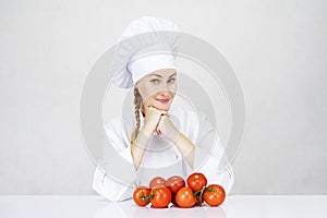 Young woman chef showing tomatos for italian food on white