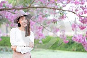 Young woman in cherry blossom garden in Spring day