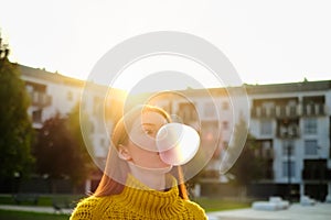 Young Woman Chewing Gum And Making Big Balloon