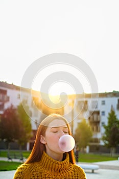 Young Woman Chewing Gum And Making Big Balloon