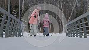 Young Woman with Child Girl Skiing in Winter Park