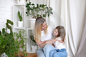 young woman and child girl spend time at home. happy motherhood weekend together with kid concept