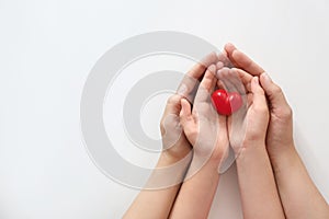 Young woman and child holding red heart