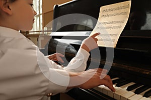 Young woman with child playing piano, closeup. Music lesson