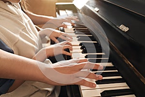 Young woman with child playing piano. Music lesson