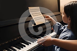 Young woman with child playing piano. Music lesson