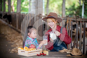 Young woman and children drinking fresh milk in a dairy farm