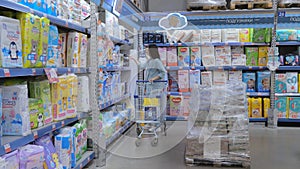 Hygiene products for children. Young mother chooses diapers in the supermarket in the mall. Tomsk, Russia 2022