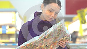 Young woman chooses frozen vegetables in the supermarket