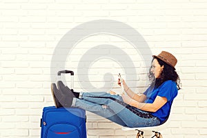 Young woman chooses a place to travel using map sitting in office travel agency. Adventure, vacation and holiday concept