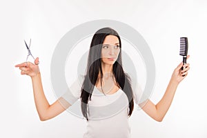 Young woman chooses scissors or comb, long hair or short