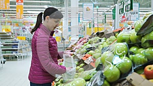 Young Woman Choosing Apples at Grocery Store