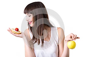 Young woman choosing cake instead of apple