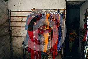 Young woman choosing clothes in African store