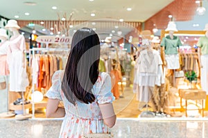 Young woman choosing clothes in clothing store at the mall, woman shopping lifestyle concept