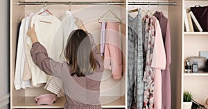 Young woman is choosing clothes on a rack in closet searching what to wear.