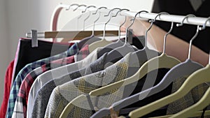 Young woman choosing clothes on a rack searching what to wear. Store or wardrobe