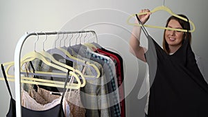 Young woman choosing clothes on a rack searching what to wear. Store or wardrobe