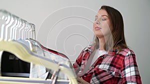 Young woman choosing clothes on a rack searching what to wear. Store or wardrobe