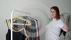 Young woman choosing clothes on a rack searching what to wear. Store or wardrobe