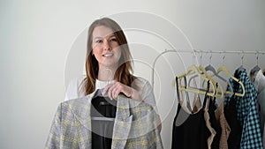 Young woman choosing clothes on a rack searching what to wear. Store or wardrobe