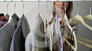 Young woman choosing clothes on a rack searching what to wear. Store or wardrobe