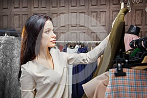 Young woman choosing clothes on a rack in a showroom
